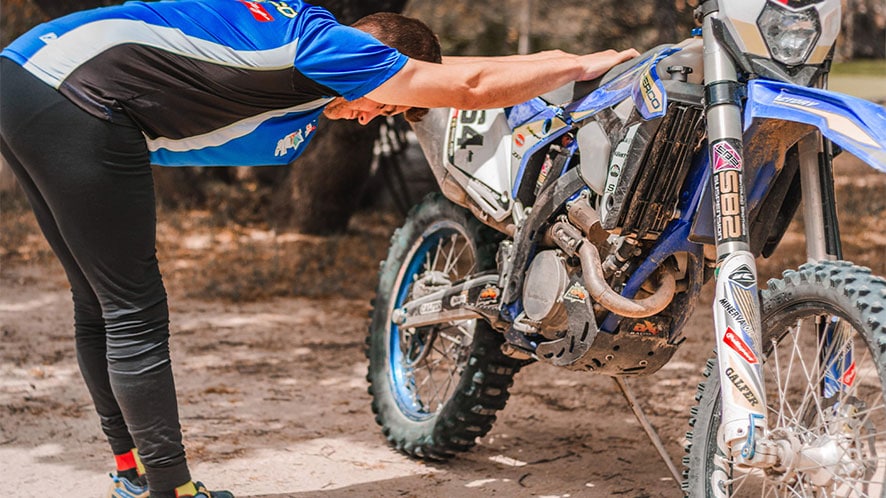 rider stretching and recovering from arm pump on the bike